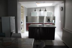 a kitchen with a sink and a refrigerator at La maison de la Place in Chooz