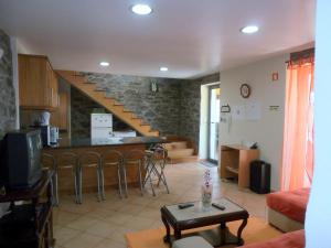a living room with a kitchen and a staircase at Quinta Escola in Arco da Calheta