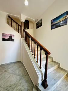 a staircase in a home with paintings on the walls at B&B - Piazza Grande in Gela