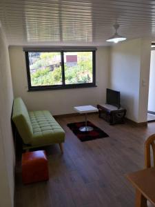 - un salon avec un canapé et une table dans l'établissement Quinta Escola, à Arco da Calheta