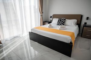 ein Schlafzimmer mit einem großen Bett mit einer orangefarbenen Decke in der Unterkunft Cittadella View Penthouse with Jacuzzi in Victoria