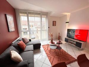 sala de estar con sofá y TV de pantalla plana en NEW : Le Terracotta proche Metz, 