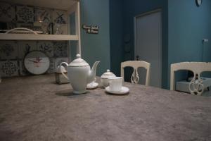 Una mesa con dos tazas de té y tazas. en Pomah Guest House, en Alastuwo