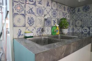 cocina con fregadero y azulejos azules y blancos en Pomah Guest House, en Alastuwo
