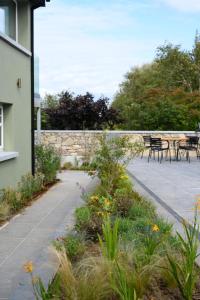 a garden with tables and chairs next to a wall at WITHIN THE VILLAGE in Galway