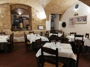 a restaurant with white tables and chairs in a room at Hotel Pax in Assisi