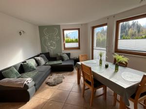 ein Wohnzimmer mit einem Tisch und einem Sofa in der Unterkunft Haus Widauer in Breitenbach am Inn