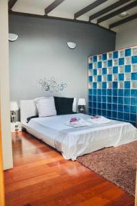 een slaapkamer met een bed met een blauwe tegelmuur bij Villa Terol, à proximité de l’océan in Saint-Paul