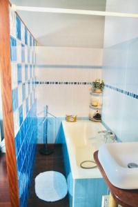 een blauwe en witte badkamer met een wastafel bij Villa Terol, à proximité de l’océan in Saint-Paul