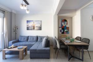 sala de estar con sofá azul y mesa en Athens Luxuery 3BR, en Atenas