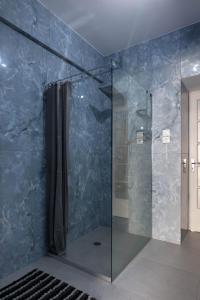 baño con ducha con pared azul en Athens Luxuery 3BR, en Atenas