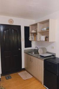 eine kleine Küche mit einer schwarzen Tür und einem Waschbecken in der Unterkunft Staycation in Marilao in Marilao