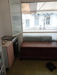 Habitación pequeña con ventana, cama y cocina. en Casa Piacquadio, en Bari