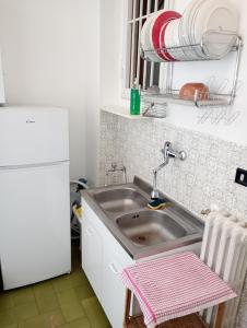 a kitchen with a sink and a white refrigerator at Casa Piacquadio in Bari