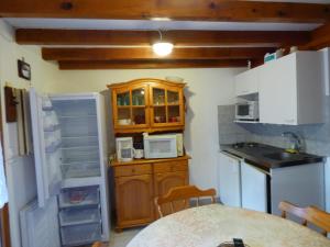 eine kleine Küche mit einem Kühlschrank und einem Tisch in der Unterkunft FINETTE in Gruissan