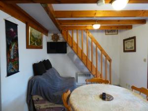 Zimmer mit einem Tisch mit Stühlen und einer Treppe in der Unterkunft FINETTE in Gruissan