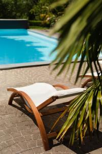 a lounge chair next to a swimming pool at Moulin de Tessé in Flexanville