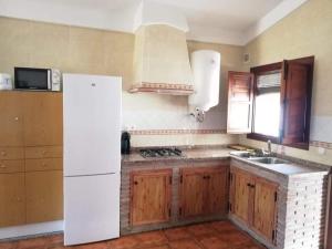eine Küche mit einem weißen Kühlschrank und einer Spüle in der Unterkunft Casa Rural El Mirador in Vélez-Málaga