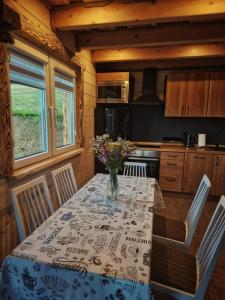 uma cozinha com uma mesa com um vaso de flores em Kryjówka Yetiego Domek w zaciszu Bieszczad z jacuzzi em Hoczew