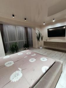 Habitación grande con cama grande y TV de pantalla plana. en 2к шикарний люкс!, en Khmelʼnytsʼkyy