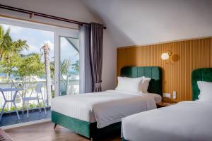 2 camas en una habitación de hotel con balcón en Koh Apikjun Resort en Kaoh Sdach