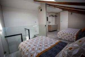 ein Zimmer mit 2 Betten und einem Schrank darin in der Unterkunft Domus 25 in Catania