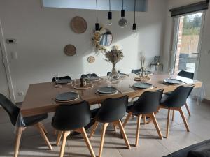 tavolo da pranzo con sedie nere intorno di Gite Comme chez soi a Spa