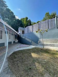 un bâtiment avec une clôture et un arbre dans la cour dans l'établissement Rilassare stays cottage, à Pedong