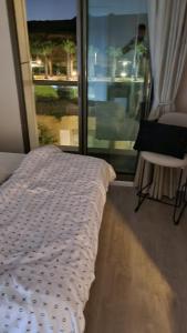 a bed sitting in a room with a window at Haigen 4 in Herzliya