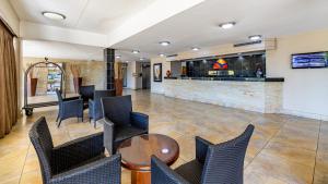 a lobby with chairs and a table and a bar at African Sky Ermelo Inn in Ermelo