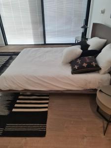 a bed with white sheets and pillows in a room at Haigen 4 in Herzliya
