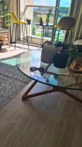 a glass table with two chairs sitting on a floor at Haigen 4 in Herzliya