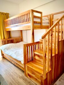 um quarto com 2 beliches e uma escada em YourHomeAway,LuxFlat at BristleRidge Baguio em Baguio