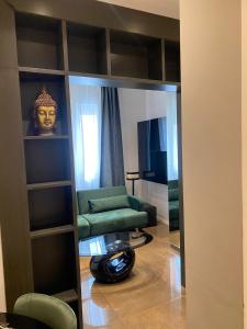 a living room with a green couch and a mirror at EUR suite BEETHOVEN in Rome