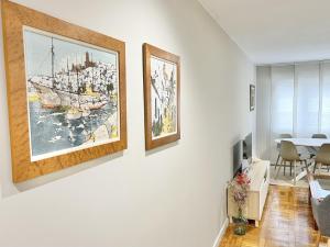 una sala de estar con 3 pinturas en la pared en Vetusta Nest, en Oviedo