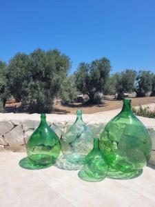 a group of four green glass vases sitting on a table at Villa Dolce Far Niente Ostuni in Ostuni +30 photos