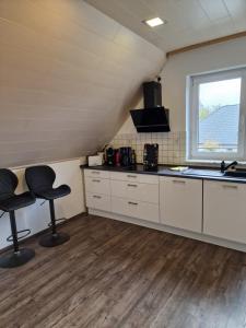eine Küche mit zwei Hockern in einem Zimmer mit einem Fenster in der Unterkunft Haus der Erholung App OG in Lotte