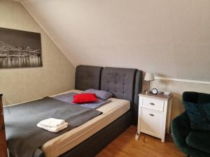 ein Schlafzimmer mit einem Bett mit einem roten Kissen darauf in der Unterkunft Haus der Erholung App OG in Lotte
