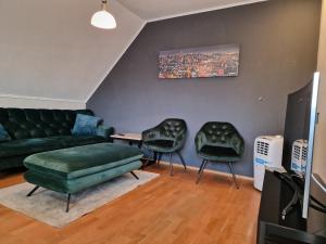 a living room with a couch and two chairs at Haus der Erholung App OG in Lotte