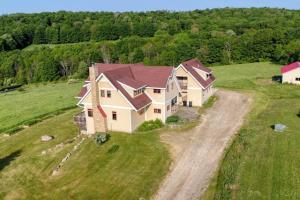an aerial view of a house in a field at Huge Home w Studio Apt-Mountain Views-Hot Tub-Sauna in Ellicottville