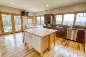 a large kitchen with wooden floors and windows at Huge Home w Studio Apt-Mountain Views-Hot Tub-Sauna in Ellicottville