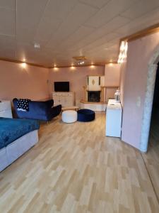 una gran sala de estar con muebles azules y una cocina. en Haus der Erholung App 2, en Lotte