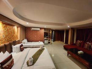 Habitación de hotel con 2 camas y sala de estar. en Star Residency Hotel, en Pattaya central