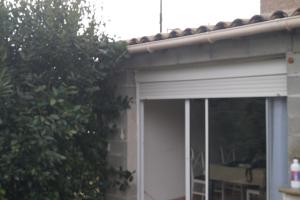 eine Garagentür mit Dach auf einem Haus in der Unterkunft Repos en campagne in Pexiora
