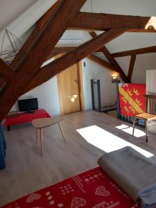 un soggiorno con soffitti in legno e tappeto rosso di Gite Schlossberg a Colmar