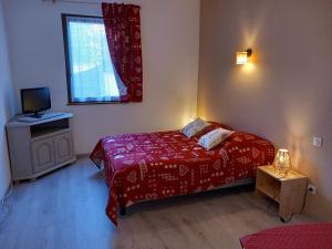 a small bedroom with a red bed and a window at Gite Schlossberg in Colmar