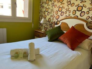 Un dormitorio con una gran cama blanca con almohadas de colores. en Tonpoigane, en Bermeo