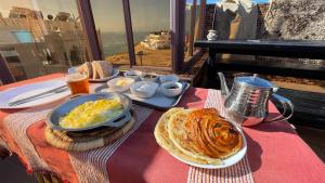 a table with a breakfast of eggs and bread on it at TOODA House in Imsouane