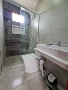 a bathroom with a sink and a toilet and a shower at Chalés Jacumã Paradise in Jacumã