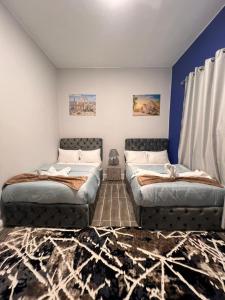 twee bedden in een kamer met blauwe muren bij downtown Family Suites in Caïro